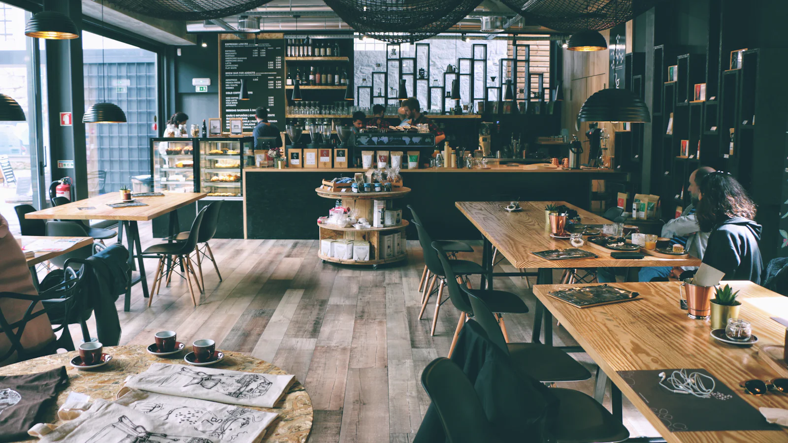 The Ember & Oat room: wooden tables, black pendant lamps and a long service counter