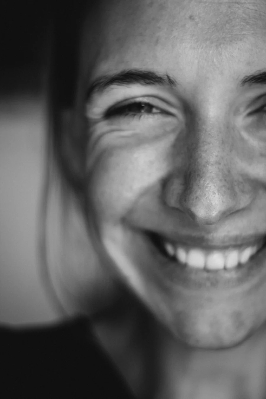 A patient smiling, photographed in black and white