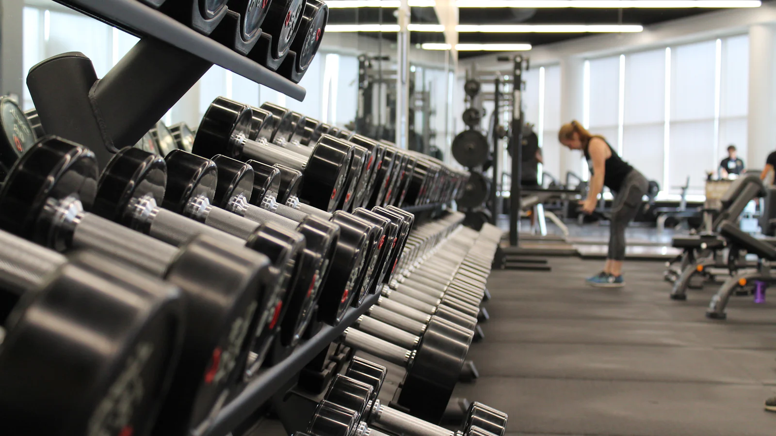 A long rack of dumbbells running down the Forma Studio training floor