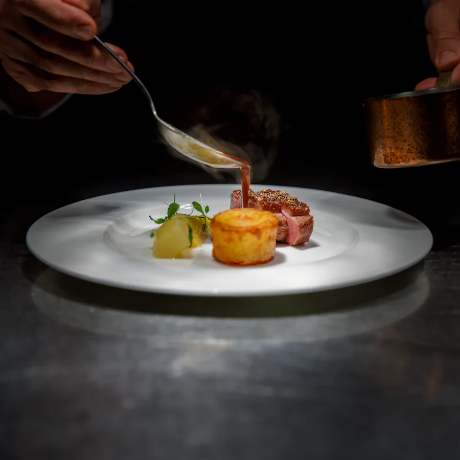 A plate being finished in the kitchen