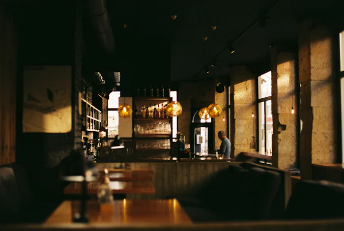 Dim restaurant room lit by warm amber pendant lights
