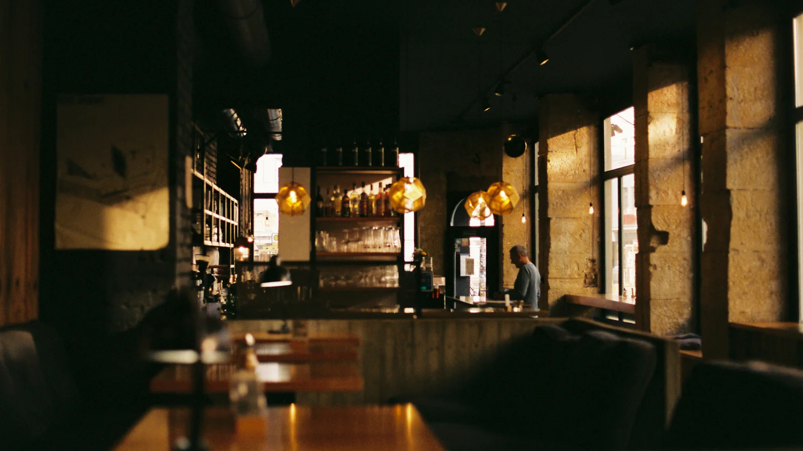 The Harbor & Vine dining room at dusk, lit by amber pendant lamps