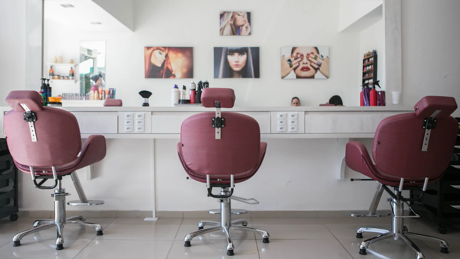 The Rosewater salon: rose-coloured styling chairs, soft cream walls and warm daylight